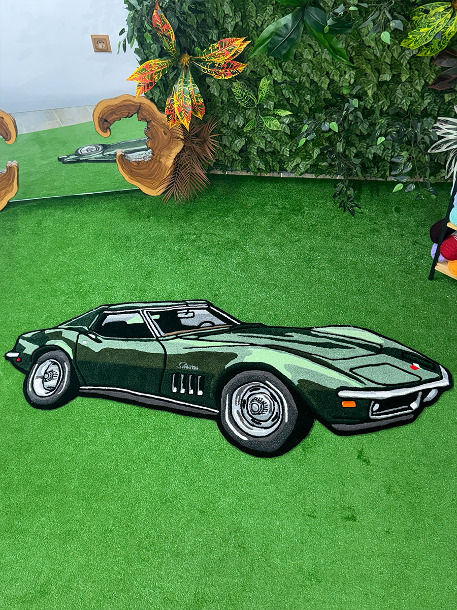 Yeşil renkli Chevrolet Corvette Stingray C3 tasarımlı el yapımı tufting halı modelinin çim zemin üzerindeki tam boy görünümü ve ikonik aerodinamik hatları.