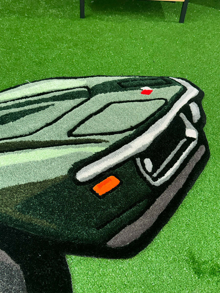 Corvette tufting halı modelinin ön far, tampon ve ızgara kısımlarındaki el dokuması detaylarını ve canlı yeşil iplik kalitesini gösteren yakın çekim.