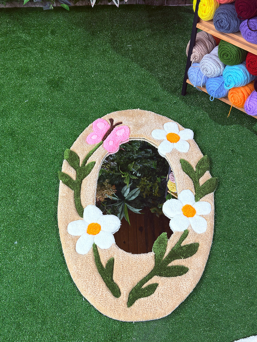 Beyaz papatyalar ve estetik pembe kelebek detayıyla zenginleştirilmiş, modern dekorasyona uygun el yapımı tufting duvar halısı ayna modeli.