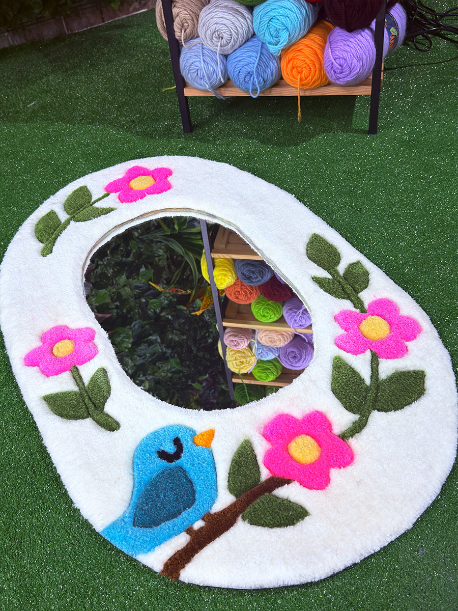Floris model el yapımı tufting duvar halısı aynanın alt köşesinde yer alan, kabartmalı (3D carving) mavi kuş ve canlı pembe çiçek işlemesi detayı.