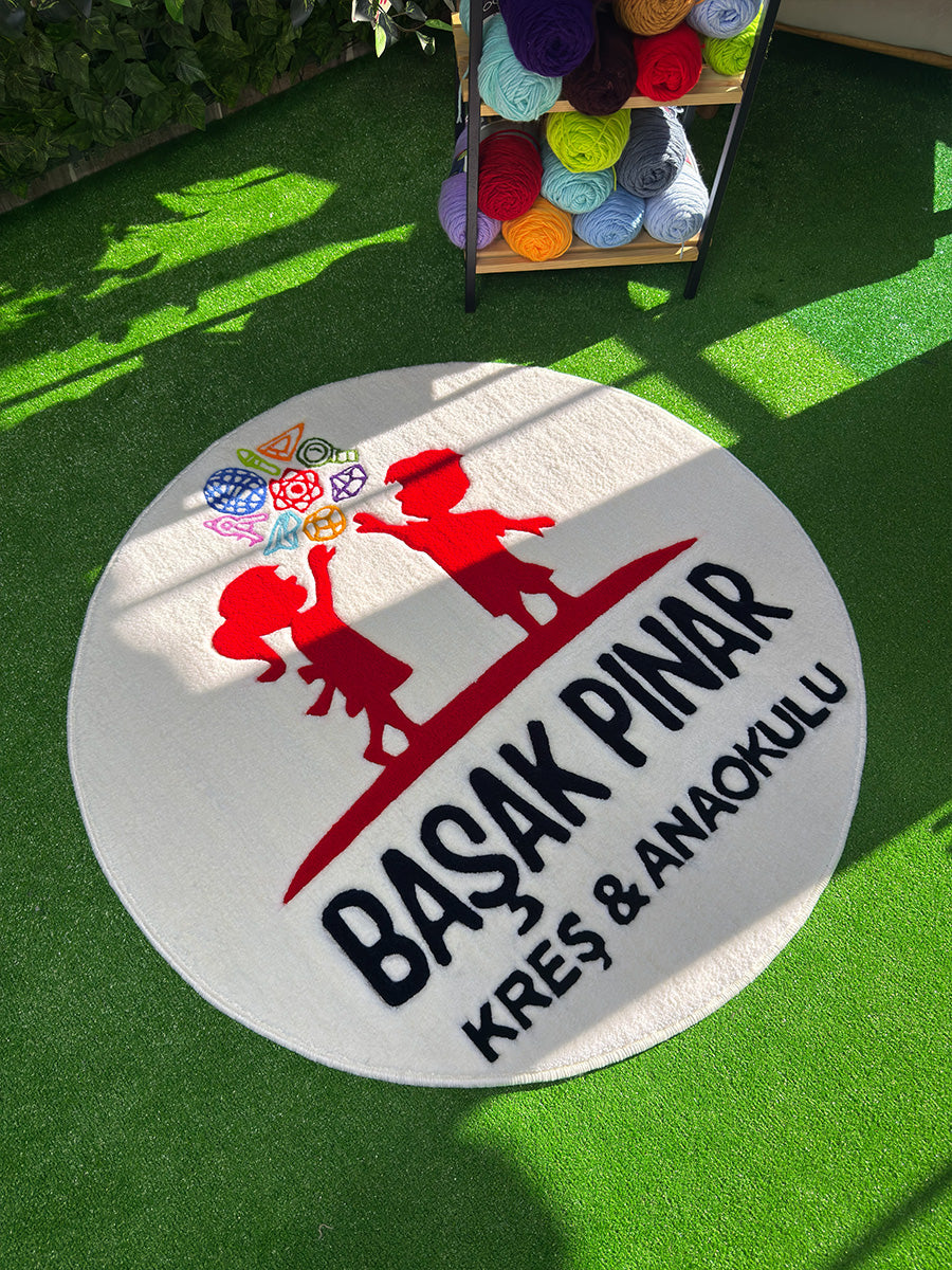 Logonun sol üst köşesindeki mavi renkli ipliklerin dolgunluğunu ve carving işleminin derinliğini gösteren, dekoratif amaçlı kurumsal tufting duvar halısı detayı.