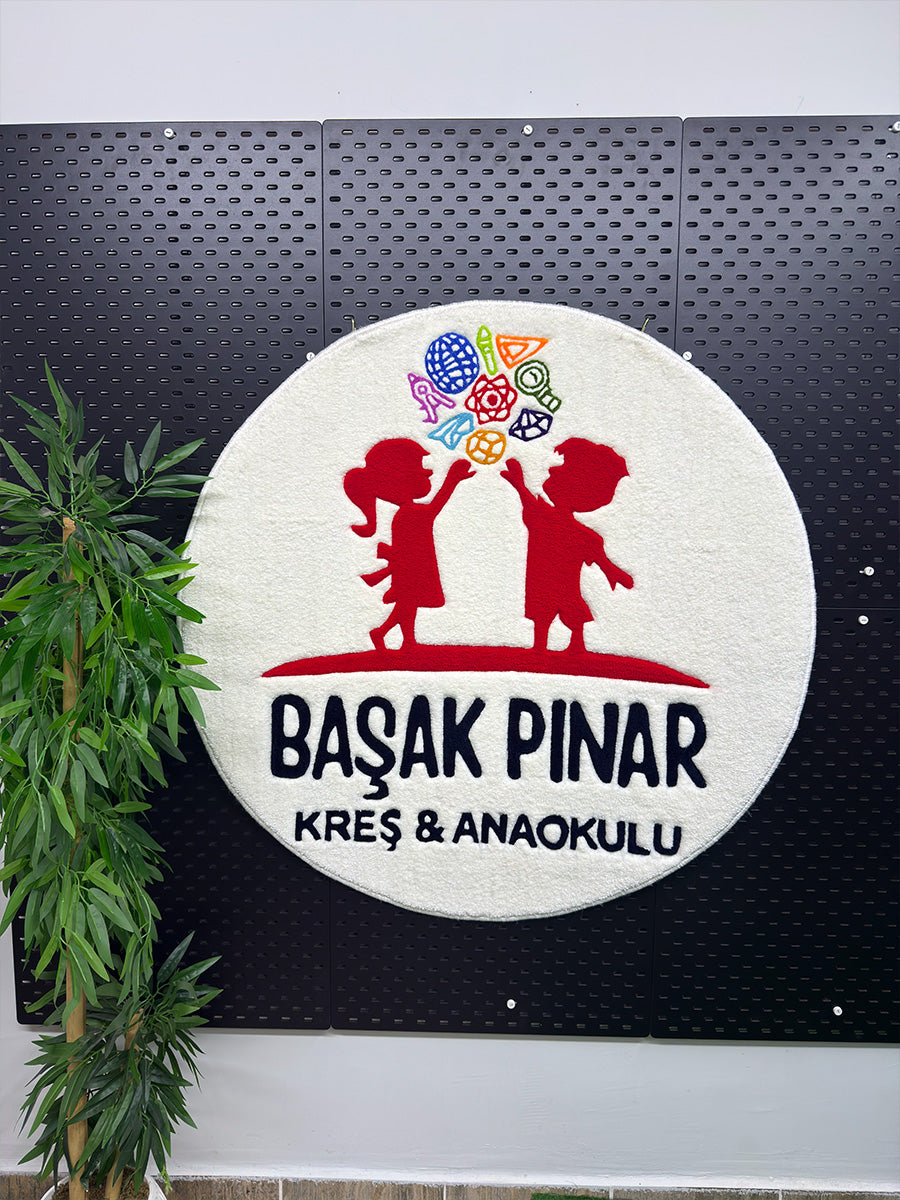 Marka kimliğini sanatsal bir dokunuşla yaşam alanlarına taşıyan, canlı renklere sahip logolu yuvarlak formda el yapımı tufting duvar halısı genel görünümü.