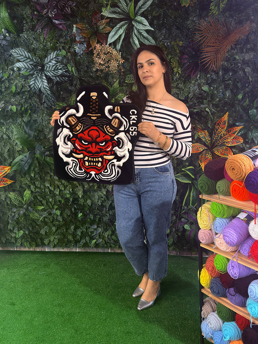 Kalın dokusu ve canlı kırmızı renkli savaşçı maskesi deseniyle dikkat çeken, etrafı duman efektleriyle çevrili el dokuması premium tufting halı oto paspası.