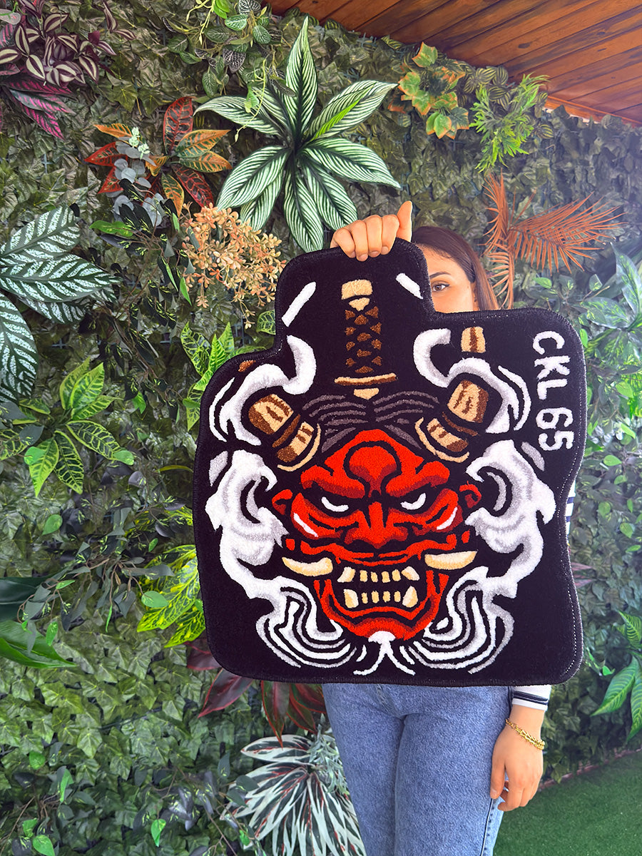 Yoğun akrilik iplikten üretilen yüzeyinde maskenin heybetli ve simetrik yapısını net bir şekilde sergileyen, yoğun detaylı özel tasarım Onix tufting halı şoför paspası.