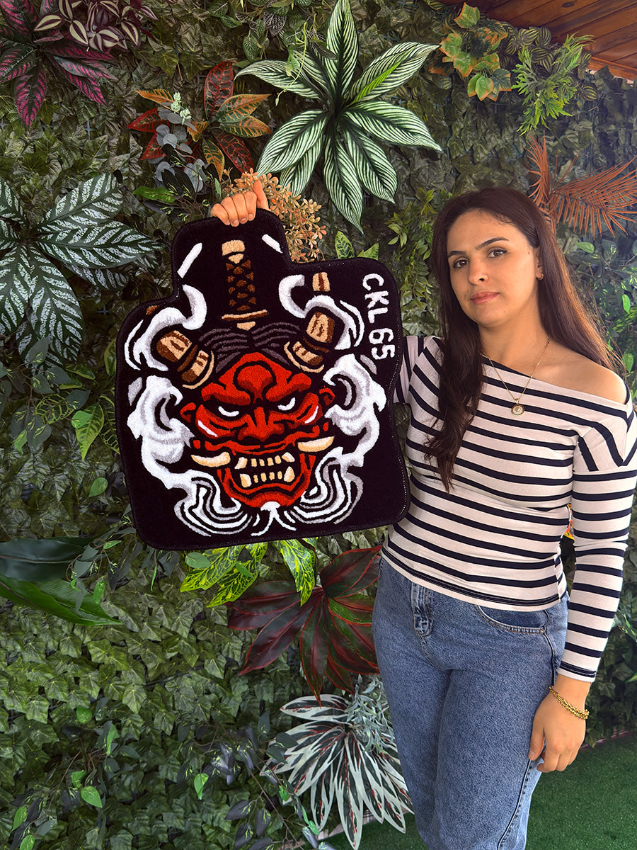 Belirli bir araç kalıbına göre şekillendirilmiş kavisli kenar yapısı ve sert bakışlı Oni maskesi figürüyle şoför mahallini kişiselleştiren el işçiliği tufting halı zemin kaplaması.