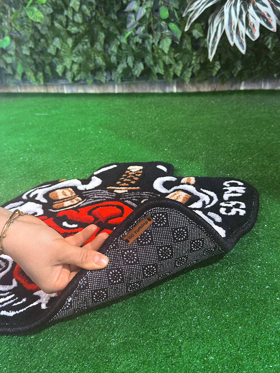 Sürüş güvenliği sağlayan çift katmanlı kaydırmaz özel taban yapısını ve GG Tufting deri logosunu gösteren, premium işçilikli el yapımı tufting halı araç içi paspas detayı.