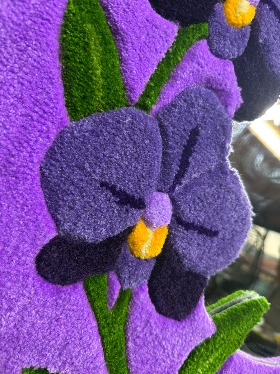 ORCHIS tufting ayna üzerindeki mor orkide çiçeğinin merkez detayı; sarı ve koyu mor renk geçişleri ile sağlanan sanatsal derinlik.