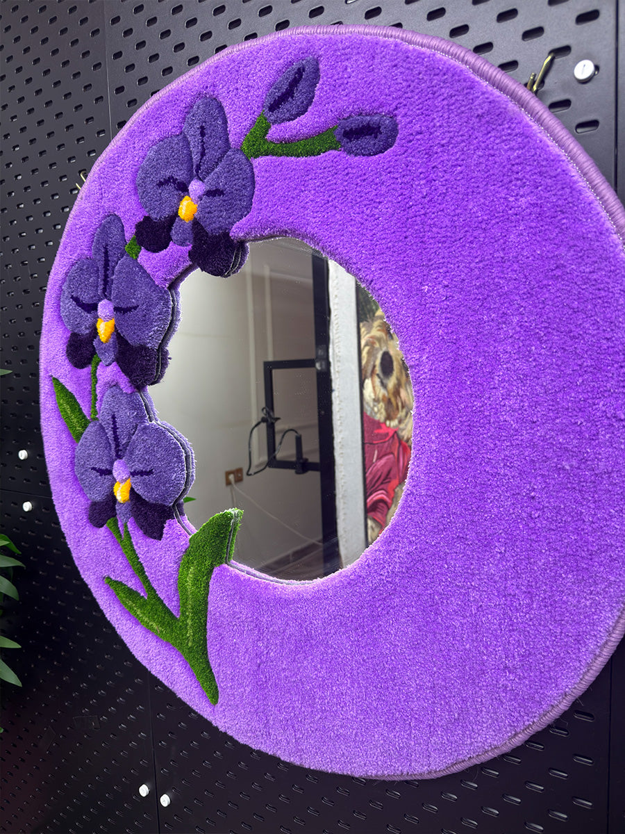 Yan açıdan çekilmiş Orchis el yapımı tufting ayna üzerindeki mor orkide figürlerinin belirgin 3D kabartma detayları ve yumuşak dokulu mor çerçeve yapısı.