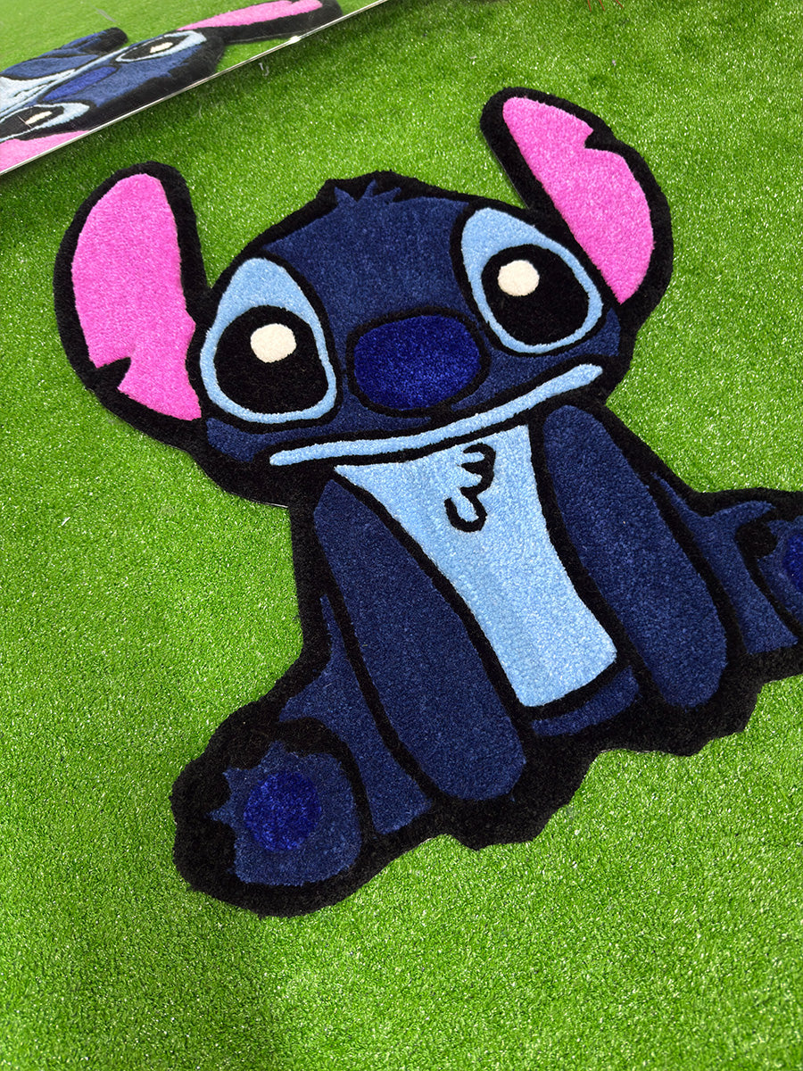 Yakından çekilmiş açılı görünümüyle %100 akrilik ipliğin yumuşak dokusunu ve 3D carving tekniğiyle boyutlandırılmış hatlarını sergileyen Stitch figürlü tufting halı. Koyu mavi gövdesi ve traşlanarak belirginleştirilmiş göz detaylarıyla öne çıkan bu el yapımı oyun odası halısı, kaliteli işçiliği gözler önüne seriyor.