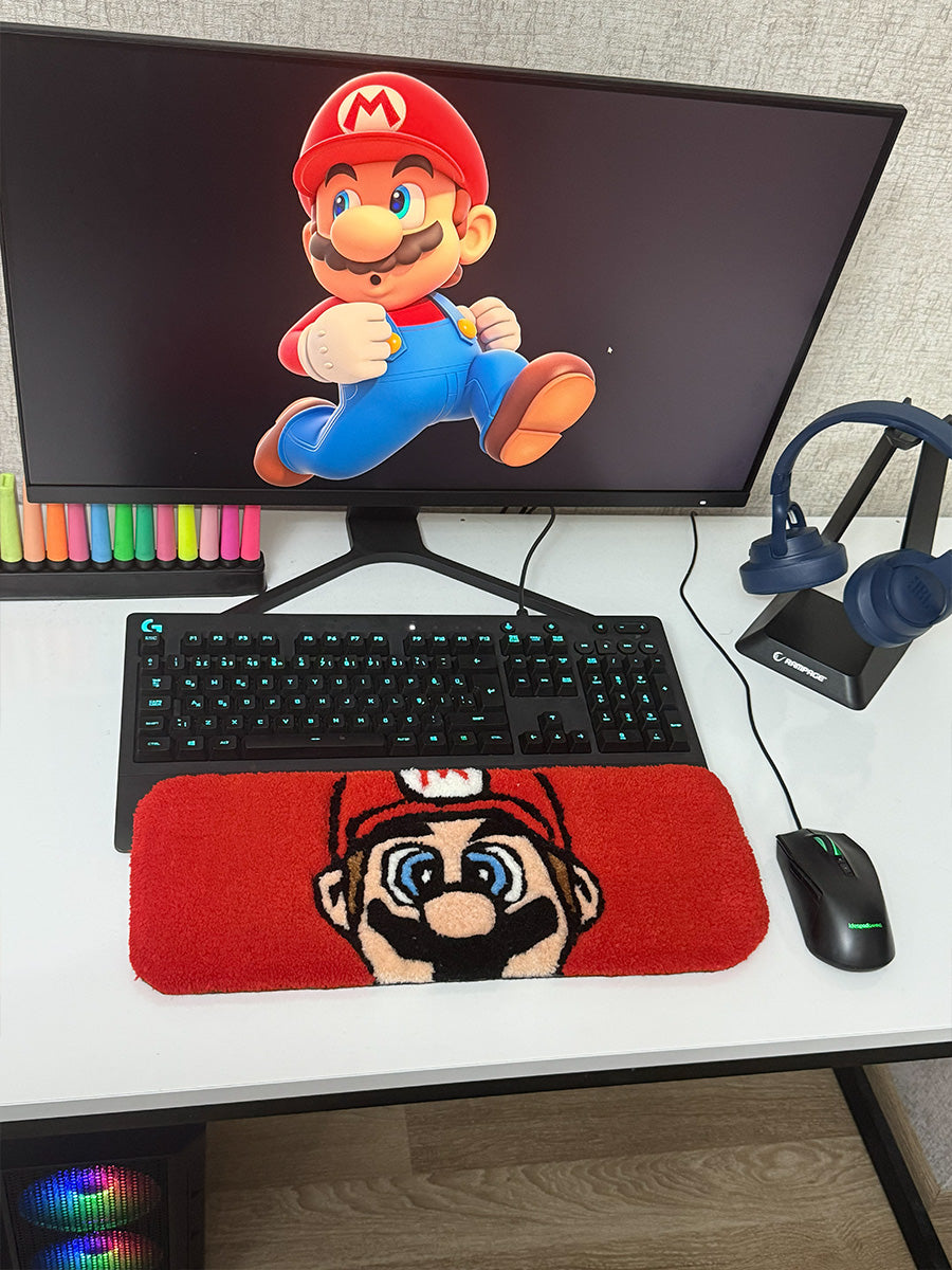 Kırmızı zemin üzerine ikonik Mario yüzü işlenmiş, yüksek havlı ve peluş dokulu el yapımı tufting klavye pedi, gaming setup'lara enerji katan yumuşak bir masaüstü tufting halısı görünümü sunar.
